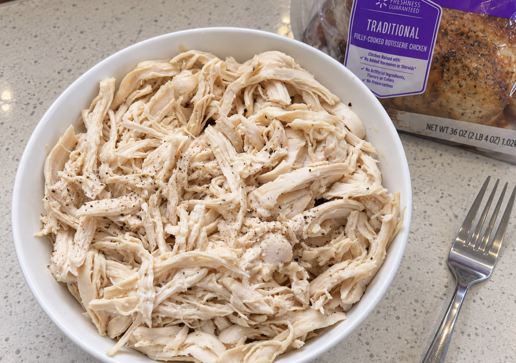 Shredded rotisserie chicken in a bowl with the skin and bones removed
